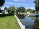 Waterfront view of a canal with lush greenery and a white picket fence running along the shoreline at 11812 Watts Ct, Tavares, FL 32778