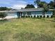 Single-story home with blue siding, a green lawn, and some landscaping and trees at 11812 Watts Ct, Tavares, FL 32778
