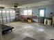 Spacious garage featuring a workbench area and large roll-up door at 11812 Watts Ct, Tavares, FL 32778