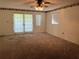 Spacious carpeted living room with sliding glass doors and natural light at 11812 Watts Ct, Tavares, FL 32778