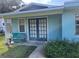 Porch with inviting French doors, seating, and manicured landscaping at 11812 Watts Ct, Tavares, FL 32778