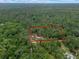 Aerial view showing the property boundaries of a home with a red roof nestled within a lush forest setting at 12288 Sw 35Th Dr, Webster, FL 33597
