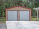 Two-car garage featuring metal siding and a concrete driveway, offering secure parking and storage space at 12288 Sw 35Th Dr, Webster, FL 33597