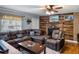 Cozy living room featuring a leather sectional, wood paneled accent wall with fireplace, and ceiling fan at 12288 Sw 35Th Dr, Webster, FL 33597