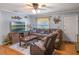 Comfortable living room featuring a leather sectional sofa, a rustic wood accent wall, and a ceiling fan at 12288 Sw 35Th Dr, Webster, FL 33597
