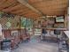 This outdoor bar is complete with TV, seating, grill, and bar; perfect for entertaining at 12288 Sw 35Th Dr, Webster, FL 33597