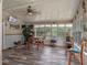 Bright sunroom with wood-look floors, large windows, ceiling fan, table and bar seating at 12288 Sw 35Th Dr, Webster, FL 33597
