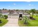Inviting single-story home featuring a three-car garage, beautiful landscaping, and a well-manicured lawn at 1376 Birdsong Pl, The Villages, FL 32163