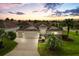 Inviting single-story home featuring a three-car garage, beautiful landscaping, and a well-manicured lawn at 1376 Birdsong Pl, The Villages, FL 32163