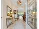 Elegant foyer with tile flooring, decorative mirror, and a glimpse into the living room at 1376 Birdsong Pl, The Villages, FL 32163