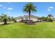 Well-maintained lawn with lush landscaping and palm trees surrounding a charming home at 1376 Birdsong Pl, The Villages, FL 32163
