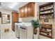 Well-organized laundry room with ample storage cabinets and shelving for supplies at 1376 Birdsong Pl, The Villages, FL 32163