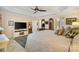 Spacious main bedroom featuring a ceiling fan, television, dresser with mirrors and a luxurious bed at 1376 Birdsong Pl, The Villages, FL 32163