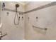 Tiled shower featuring a built-in niche, a handheld shower head and a convenient grab bar at 1376 Birdsong Pl, The Villages, FL 32163