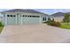 Spacious concrete driveway leading to a two-car garage with manicured lawn at 1449 Jeremy Cir, The Villages, FL 34762