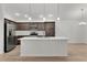 Modern kitchen features an island, stainless steel appliances, and sleek dark wood cabinets at 1449 Jeremy Cir, The Villages, FL 34762