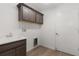 Well-lit laundry room features modern cabinets, a sink, and connections for a washer and dryer at 1449 Jeremy Cir, The Villages, FL 34762
