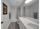 Bright bathroom features double sinks, patterned tile floors, and a shower-tub combination at 14501 Wabasso Loop, Winter Garden, FL 34787