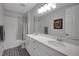 This bathroom has double sinks, patterned tile floors, a shower-tub, and neutral wall color at 14501 Wabasso Loop, Winter Garden, FL 34787