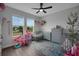 Bright and playful bedroom with two cribs, a dollhouse, and a large window overlooking the neighborhood at 14501 Wabasso Loop, Winter Garden, FL 34787