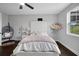 This bedroom features a ceiling fan, dark hardwood floors, and an upholstered headboard at 14501 Wabasso Loop, Winter Garden, FL 34787