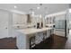 Elegant white kitchen with a large quartz island, pendant lights, and modern appliances at 14501 Wabasso Loop, Winter Garden, FL 34787