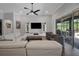 Comfortable living room featuring a large TV, stylish furniture, and sliding glass doors to the patio at 14501 Wabasso Loop, Winter Garden, FL 34787