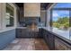 Covered outdoor kitchen includes a built-in grill, stainless steel appliances, and granite countertops at 14501 Wabasso Loop, Winter Garden, FL 34787