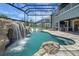Private, screened pool area features a waterfall, slide, outdoor seating, and outdoor kitchen at 14501 Wabasso Loop, Winter Garden, FL 34787