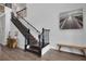Elegant staircase with dark wood and wrought iron railings, complemented by wood floors and wall art at 14501 Wabasso Loop, Winter Garden, FL 34787