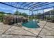 Screened-in swimming pool boasts a rock waterfall, slide, in-water seating, and lush landscape views at 14501 Wabasso Loop, Winter Garden, FL 34787