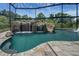Resort-style pool featuring a rock waterfall, slide, and lush landscaping under a screened enclosure at 14501 Wabasso Loop, Winter Garden, FL 34787