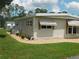 Exterior view of home with maintained lawn, bushes, awnings, and white siding at 146 Hibiscus Way, Leesburg, FL 34748