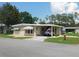 Charming single-story home with a carport and well-maintained landscaping under a sunny sky at 146 Hibiscus Way, Leesburg, FL 34748