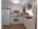 Bright kitchen features white cabinets, appliances, and a tile floor at 146 Hibiscus Way, Leesburg, FL 34748