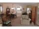 Cozy living room with neutral walls, floral sofa, table, and visible kitchen in the background at 146 Hibiscus Way, Leesburg, FL 34748