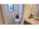 Small toilet room featuring a toilet, sink, and decorated with house-themed decor at 1550 Ward Ct, The Villages, FL 32162