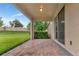 Covered back patio offering a peaceful outdoor space with views of the lush lawn at 15531 Waterleigh Cove Dr, Winter Garden, FL 34787