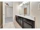 Bathroom with double sink vanity featuring dark cabinets, white countertops, and neutral tile flooring at 15531 Waterleigh Cove Dr, Winter Garden, FL 34787