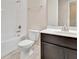 Bathroom featuring a white toilet, dark cabinets, and combined bathtub and shower with white tile at 15531 Waterleigh Cove Dr, Winter Garden, FL 34787