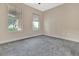 Well-lit bedroom featuring plush gray carpeting, neutral walls, and windows offering scenic outdoor views at 15531 Waterleigh Cove Dr, Winter Garden, FL 34787