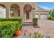 Charming front entrance with arched entryway, brick walkway, and well-maintained landscaping at 15531 Waterleigh Cove Dr, Winter Garden, FL 34787