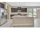 Spacious kitchen featuring an island, stainless steel refrigerator, dark cabinets, and granite countertops at 15531 Waterleigh Cove Dr, Winter Garden, FL 34787
