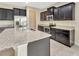 Open kitchen with large island featuring granite countertops, stainless steel appliances, and dark cabinetry at 15531 Waterleigh Cove Dr, Winter Garden, FL 34787