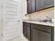 Well-equipped laundry room with sleek, dark cabinets and granite countertops at 15531 Waterleigh Cove Dr, Winter Garden, FL 34787
