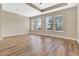 Large primary bedroom featuring a tray ceiling, recessed lights, wood flooring, and an abundance of natural light at 15531 Waterleigh Cove Dr, Winter Garden, FL 34787
