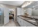 Bathroom boasts double sinks, granite counters, white cabinets, and shower access at 1640 Marsh Pointe Dr, Clermont, FL 34711
