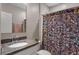 Bathroom featuring granite vanity, mirror, and vibrant floral shower curtain at 1640 Marsh Pointe Dr, Clermont, FL 34711
