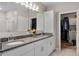 Bathroom boasts double sinks, granite counters, white cabinets, and walk-in closet access at 1640 Marsh Pointe Dr, Clermont, FL 34711