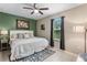 Cozy bedroom with a green accent wall, ceiling fan, and neutral toned furnishings at 1640 Marsh Pointe Dr, Clermont, FL 34711